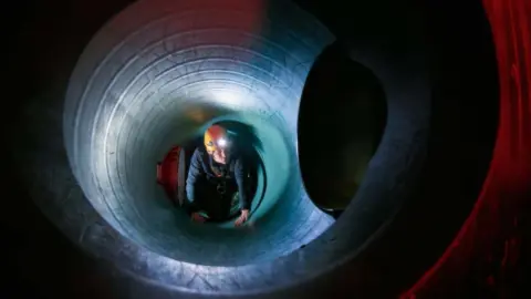 persoon kruipt door tunnel