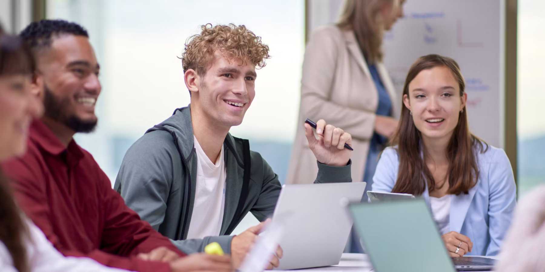 man met pen in hand bij bespreking