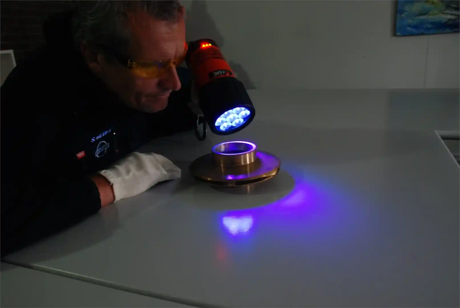man bekijkt metaal voorwerp met uv licht
