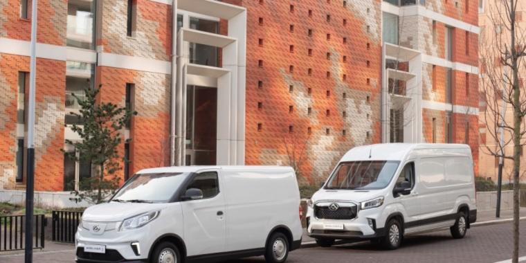 twee witte bestelbusjes voor gebouw